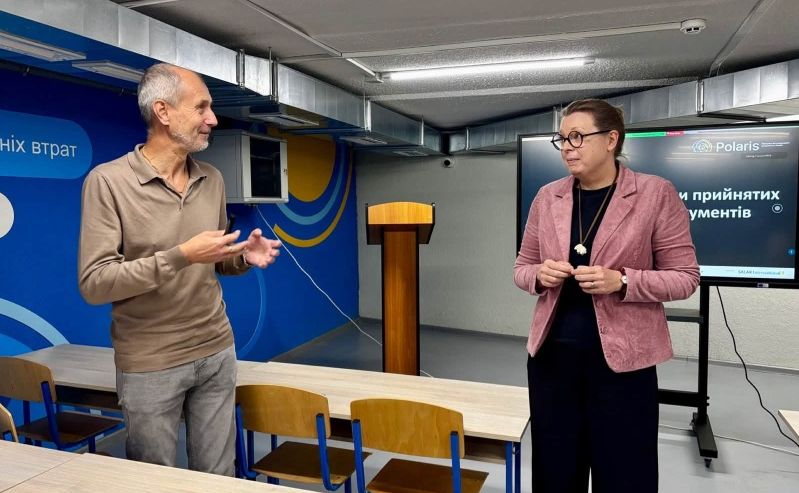 чоловік щось пояснює жінці в навчальному приміщенні в укритті