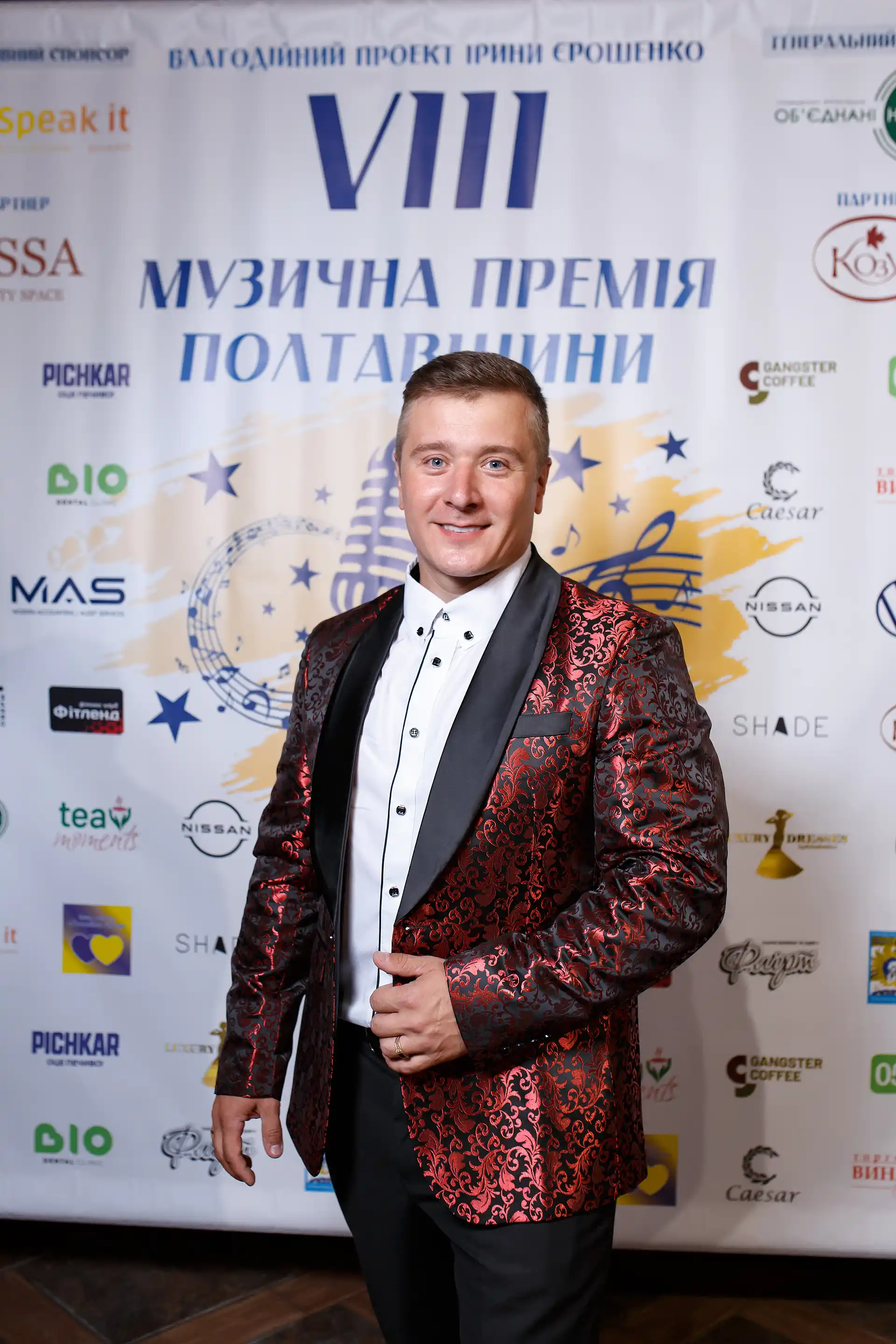 співак на тлі банера Музична премія Полтавщини