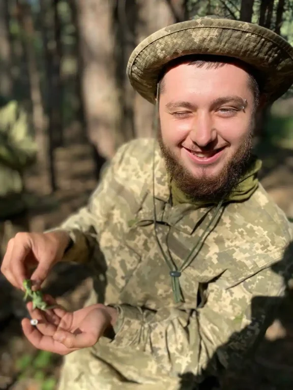 усміхнений Артем у військовій формі показує живу ящірку