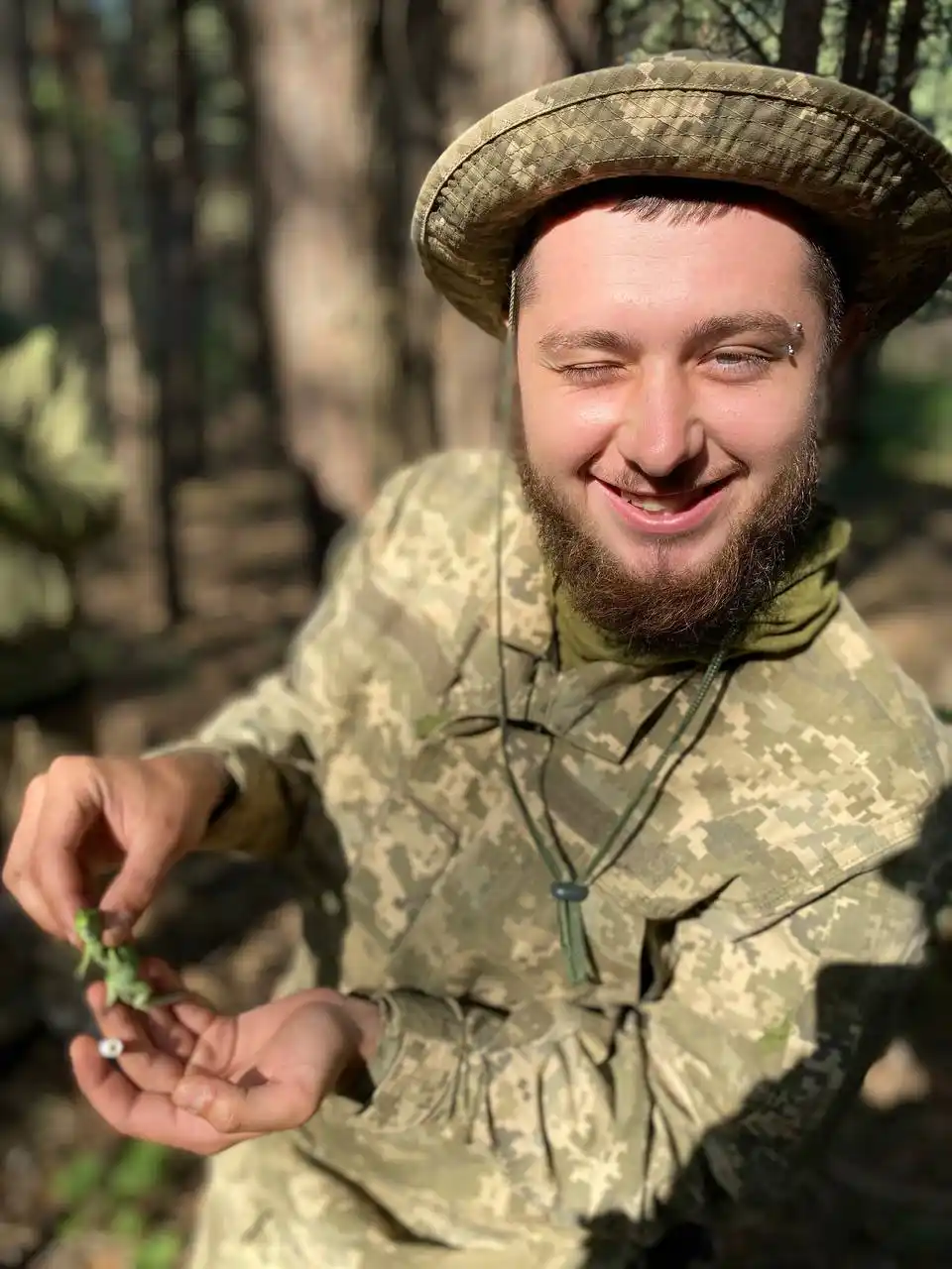 усміхнений Артем у військовій формі показує живу ящірку