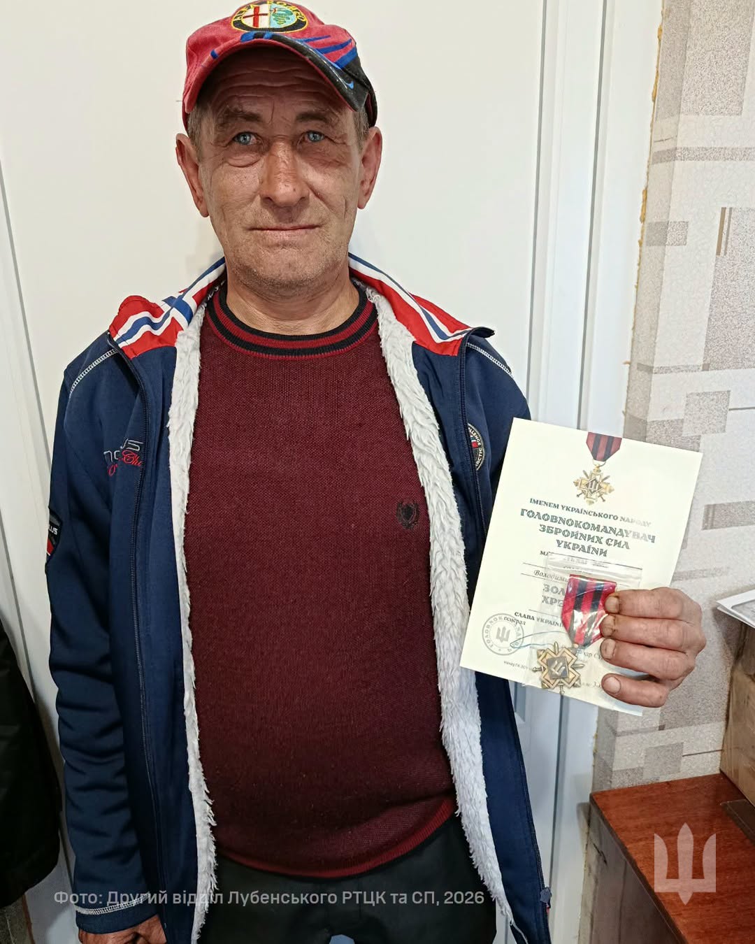 ветеран тримає в руці нагороду та свідоцтво до неї