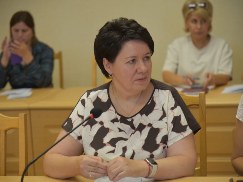 Вікторія Пилипенко сидить за столом у депутатській кімнаті обласної ради