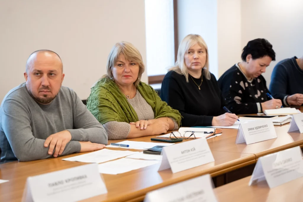 люди сидять за столом, перед ними документи