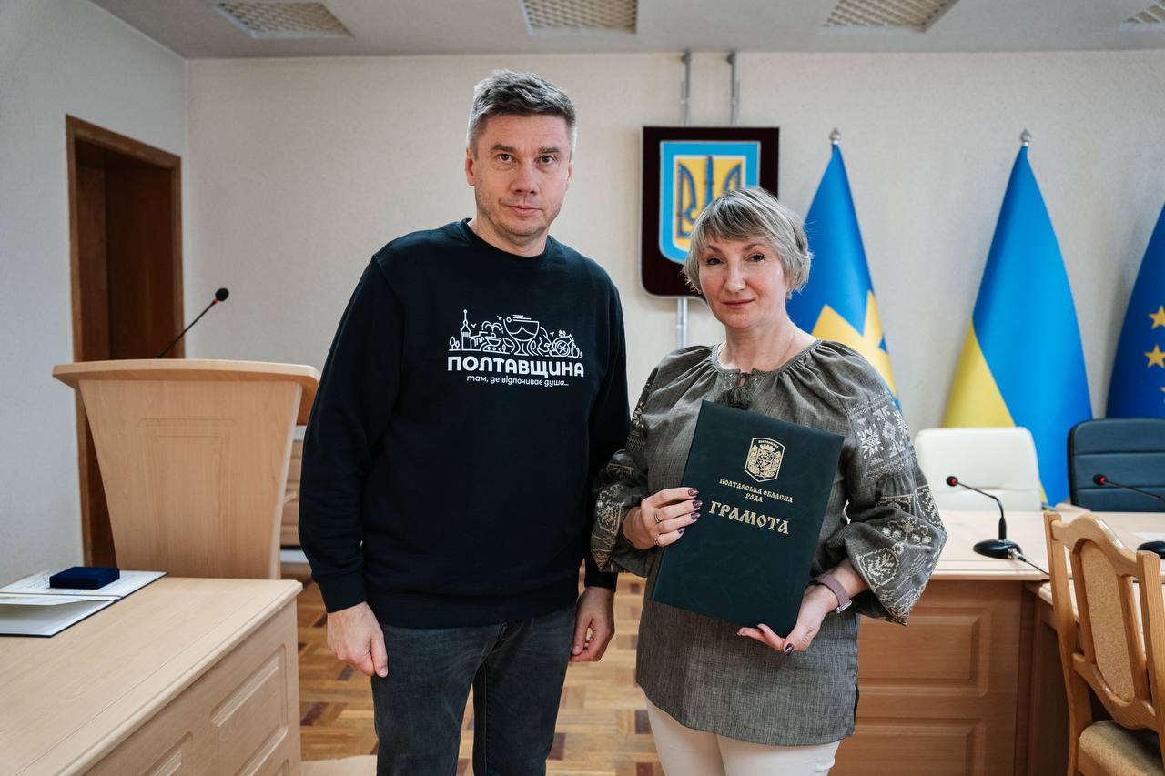 Олександр Біленький нагороджує викладачку