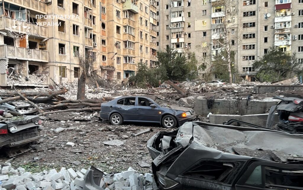 двір між будинками, які постраждали від російської атаки, всипаний склом, цеглою тощо