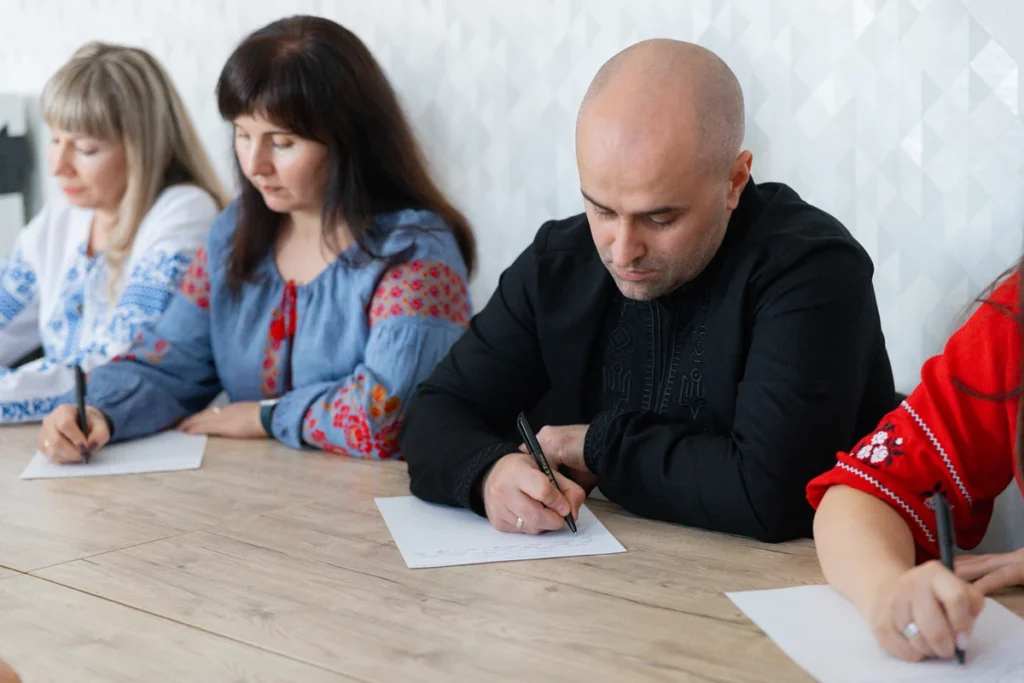 учасники диктанту пишуть текст