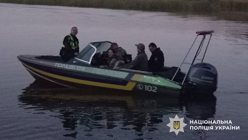 учасники пошукової групи на поліцейському катері на воді