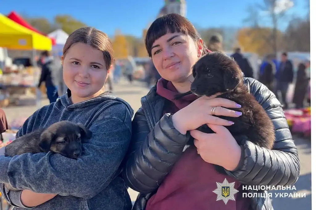 Людмила з донькою, тримають цуценят на руках
